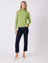 Polera de tejido fino, color rosado, con cuello alto, manga larga y detalle de tajo en los puños.