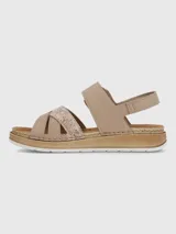 Sandalia de plataforma baja color beige con tiras cruzadas, una de ellas con acabado texturizado brillante. Presenta una tira ajustable con hebilla decorativa y cierre de velcro, sobre una suela de estilo yute con base de poliuretano.