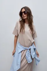 Vestido midi negro de algodón con calce relajado, silueta recta, cuello redondo, mangas cortas amplias y tajos laterales.
