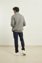 Cardigan de punto color azul marino, con cierre frontal de metal y cuello alto. Presenta tejido de punto fantasía y bolsillos laterales.