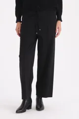 Sweater de punto color beige con cuello alto tipo polera, manga larga y detalle de botones decorativos en el hombro y cuello.