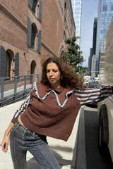 Buzo tejido marrón con cuello grande contrastante en celeste, mangas largas con rayas celestes y detalles texturizados en el cuerpo.