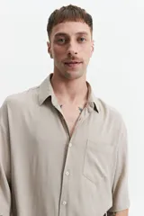 Camisa blanca de manga corta, corte oversize y cuello clásico.