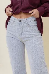 Pantalón de jean estilo wide leg, color celeste claro, con tiro medio, cinco bolsillos y cierre frontal con botón y cremallera.