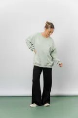 Buzo oversize de algodón frizado color beige, con cuello redondo, puños y cintura tejidos. Presenta un bordado pequeño de Snoopy en el frente.