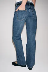 Jeans de tiro bajo y corte recto, confeccionados en denim con efecto lavado. Presentan cintura con trabillas, bolsillos delanteros y traseros, y cierre frontal con cremallera y botón.