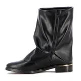 Bota de caña media en color negro, confeccionada en material sintético con acabado liso. Presenta un diseño de caña holgada con efecto arrugado y una tira decorativa lateral con hebilla metálica dorada. Cuenta con un taco bajo cuadrado y detalle de borde metálico en la base del talón.