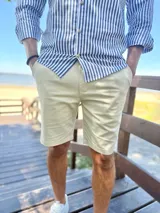 Bermuda de gabardina color beige, con bolsillos laterales y traseros, de corte recto y clásico.