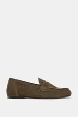 Mocasín de mujer confeccionado en serraje, con diseño de antifaz en el empeine y punta redonda. Presenta una suela plana de 2 cm.