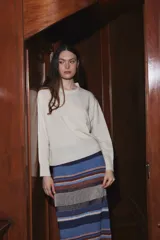 Sweater de punto color crudo, con cuello redondo, manga larga y corte holgado.