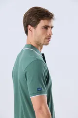 Remera polo de piqué azul marino, con cuello y puños de mangas cortas con ribete blanco en contraste, cierre frontal de dos botones y pequeño logo bordado en el pecho.