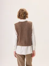 Chaleco de punto con textura jaspeada, cuello redondo y corte recto, diseñado para superponer sobre otras prendas.