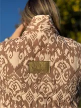 Chaqueta acolchada con estampado ikat en blanco y negro, de corte recto y cuello mao.