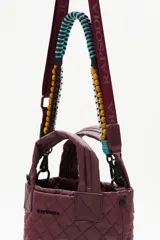 Cartera tote mini negra, con diseño matelasse y dos asas cortas. Incluye una correa larga ajustable y extraíble, con detalles de cuentas de colores.