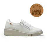 Championes deportivos casuales de cuero blanco, con diseño slip-on y cierre lateral. Presentan una suela de plataforma en tono beige con textura y detalles perforados en el lateral.