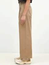 Pantalón negro de corte ancho, con pinzas en la cintura y bolsillos laterales.