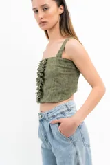 Conjunto de top corto y falda corta color verde agua. El top es de breteles anchos, corte recto y con volados verticales y botones decorativos en el frente. La falda es de corte recto con volados en el ruedo.