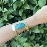 Pulsera rígida dorada con piedra ágata ovalada color verde agua.