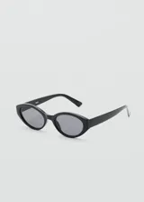 Lentes de sol con montura ovalada de pasta negra y cristales oscuros.