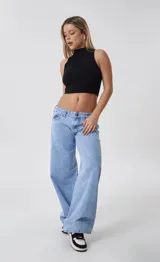 Pantalón de jean tiro bajo con corte wide leg y diseño de cinco bolsillos. Presenta un lavado celeste claro y cierre frontal con botón metálico.