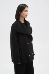 Tapado corto de paño en color beige, con cuello solapa amplio y cierre frontal cruzado con doble botonadura. Presenta mangas largas y bolsillos laterales integrados.