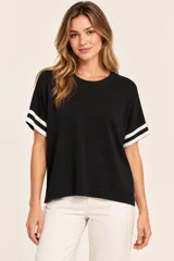 Remera de punto negra, de manga corta con detalles de doble franja blanca en las mangas, cuello redondo y corte holgado.