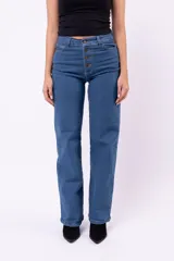 Jean wide leg azul de tiro alto, con cierre frontal de botones expuestos y bolsillos laterales.