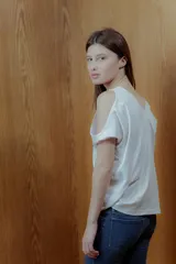 Top blanco con lurex, escote en V y hombros descubiertos.