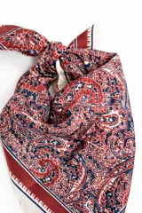 Bandana cuadrada con estampado paisley en tonos bordó, azul marino y blanco, con bordes en tono crudo y marco decorativo.