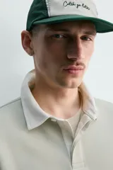 Sudadera de manga larga estilo polo con diseño de rayas horizontales anchas en azul marino y blanco. Presenta cuello de solapa en contraste, cierre frontal con botones ocultos y acabados en rib en puños y bajo.