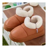 Pantuflas botitas color tostado con diseño acolchado y plataforma, forradas con corderito sintético blanco en el interior y el cuello. Cuentan con una pequeña etiqueta decorativa en el lateral.