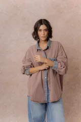 Camisa de denim color verde menta con calce relajado, cuello clásico, cierre frontal con broches metálicos, mangas largas y bolsillo aplicado en el pecho, con detalles en tono gris azulado a contraste en cuello, cartera, bolsillo y puños.