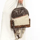 Mochila de cuero vacuno marrón y beige con estampado animal print en los bolsillos laterales.