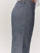 Pantalón de lino color blanco crudo, de corte barrel, con bolsillos laterales y costuras pespunteadas a contratono.