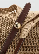 Bolso tote grande de tejido de fibra natural de papel, con doble asa larga de hombro en color marrón oscuro de poliuretano, detalles metálicos dorados y neceser interior de tela con cierre.