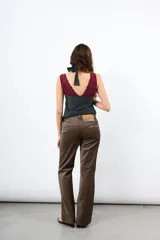 Pantalón de pana tiro alto color óxido, de corte flare y pierna ancha. Cuenta con botonadura frontal metálica y bolsillos plaqué delanteros.