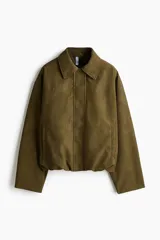 Campera bomber color verde militar de corte oversize, con cuello clásico, cierre frontal oculto bajo solapa y bolsillos laterales ribeteados.
