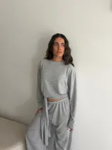 Conjunto de dos piezas de viscosa y poliéster color gris melange, compuesto por un buzo de manga larga y un pantalón largo de corte recto con lazo ajustable en la cintura.