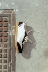 Zapatillas urbanas de cuero color beige y blanco con detalles en animal print en el talón y cordones marrones.