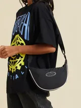 Bandolera negra de diseño curvo y estilo deportivo, con ribete blanco en el borde y logo de la marca en la parte frontal. Cuenta con correa ajustable y cierre superior.