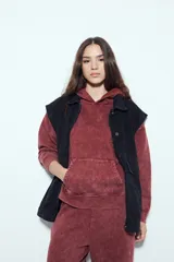 Buzo canguro color marrón oscuro con efecto lavado, calce relajado, capucha integrada, bolsillo frontal tipo canguro y terminaciones clásicas en puños y ruedo.