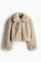 Campera corta de piel sintética en color beige, con cuello redondo, mangas largas y cierre frontal oculto.
