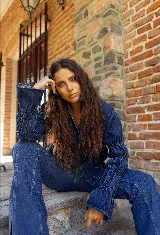 Camisa de jean azul oscuro con cuello mao, cierre frontal con botones metálicos y mangas largas con detalle de frunces elásticos.