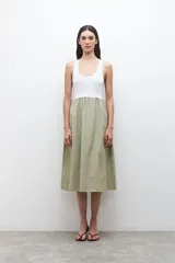 Vestido midi con parte superior blanca tipo musculosa y falda verde con rayas verticales blancas.