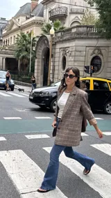 Blazer de corte sastrero con estampado de cuadros en tonos marrones y beige, con solapas clásicas, cierre frontal de dos botones y mangas largas con forro interno en contraste.