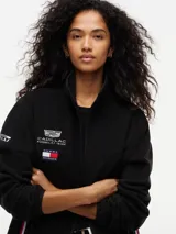 Campera de tejido polar negra Tommy Hilfiger, con cuello chimenea y cierre de cremallera. Presenta diseño Global Stripe en los laterales, bolsillos abiertos en diagonal y el logo de la marca junto con el de Cadillac Formula 1 Team en el pecho.