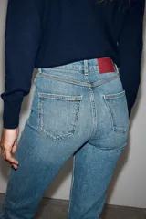 Jeans mom fit de tiro alto color negro con efecto lavado, diseño de cinco bolsillos y corte tobillero.