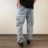 Pantalón cargo de jean azul, de corte recto y tiro medio, con bolsillos laterales con solapa en las piernas.