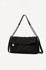 Cartera tipo bandolera de color negro con diseño acolchado en patrón de rombos. Cuenta con una solapa frontal, correa de hombro que combina material textil con cadena metálica oscura y un dije circular decorativo.