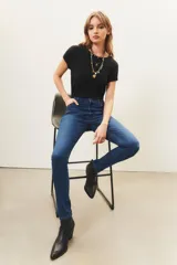 Jean de tiro medio y corte slim, confeccionado en denim azul con lavado localizado y apliques de hotfix en los bolsillos delanteros.